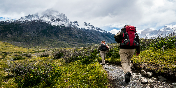 2 people walking torwards a mountain