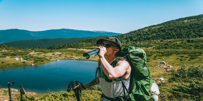 Is Hiking a Hobby? Everything You Need to Know About This Rewarding Pastime 3 A hiker with a backpack drining from a bootle